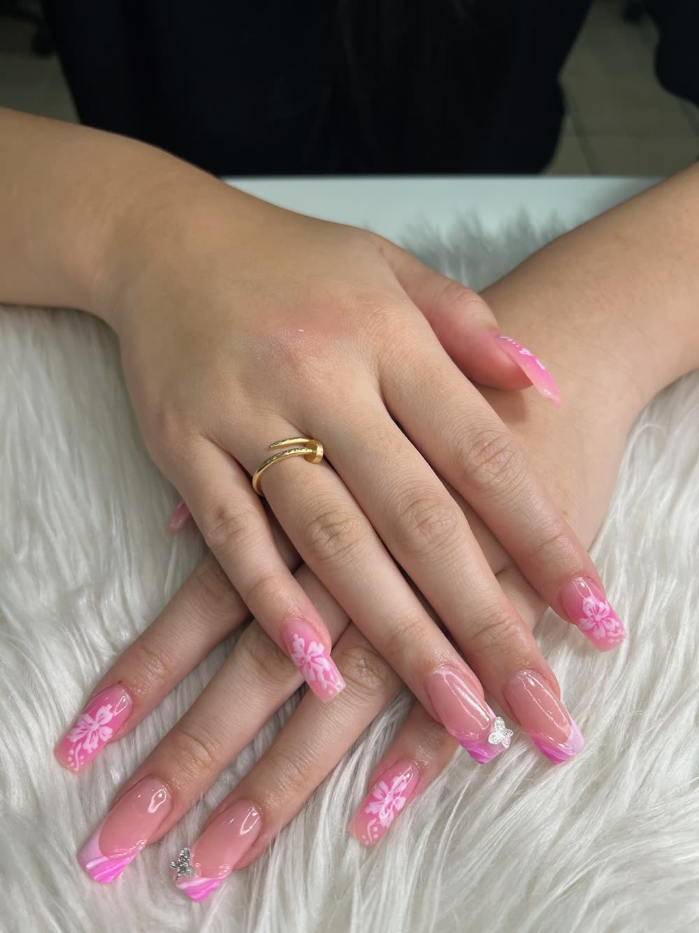 Pink ombre coffin nails with white hibiscus and a butterfly charm