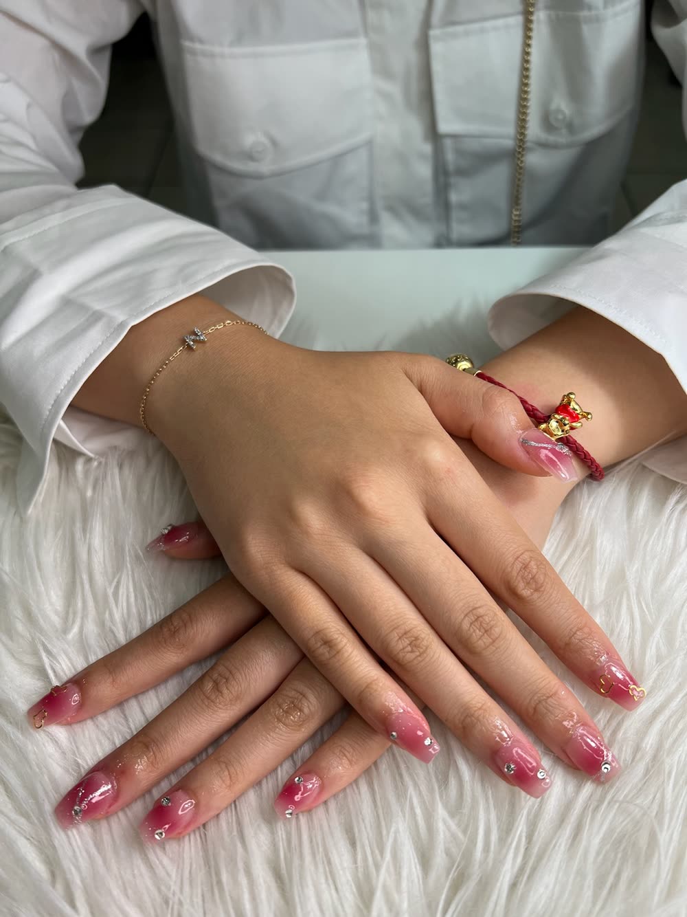 Pink and magenta ombre coffin nails with gems and gold charms
